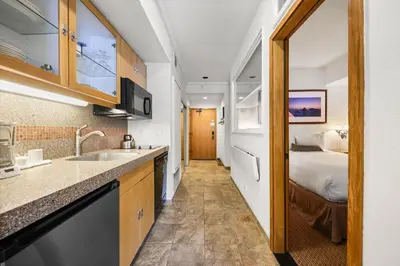 a kitchen with a sink and a bed in a room at Palisades Tahoe Lodge Rentals Studio #223 in Olympic Valley