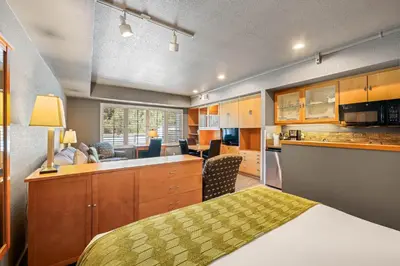 a bedroom with a bed and a kitchen at Palisades Tahoe Lodge Rentals Studio #225 in Olympic Valley