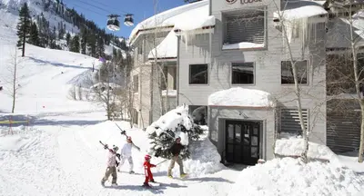 a group of people standing in the snow in front of a building at Palisades Tahoe Lodge Rentals Studio #248 in Olympic Valley