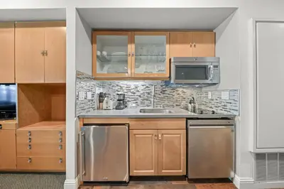 a kitchen with wooden cabinets and stainless steel appliances at Palisades Tahoe Lodge Rentals Studio #226 in Olympic Valley