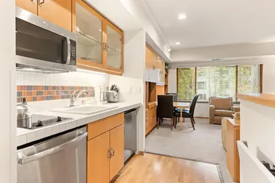 a kitchen with a sink and a dining room at Palisades Tahoe Lodge Rentals Studio #228 in Olympic Valley