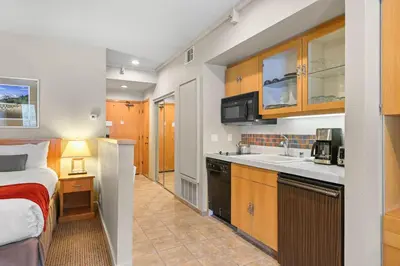 a small room with a bed and a kitchen at Palisades Tahoe Lodge Rentals Studio #237 in Olympic Valley