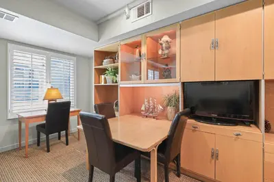 a dining room with a table and a television at Palisades Tahoe Lodge Rentals Studio #238 in Olympic Valley