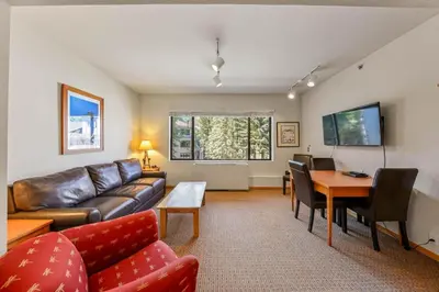 a living room with a couch and a table at Palisades Tahoe Lodge Rentals Studio #246 in Olympic Valley
