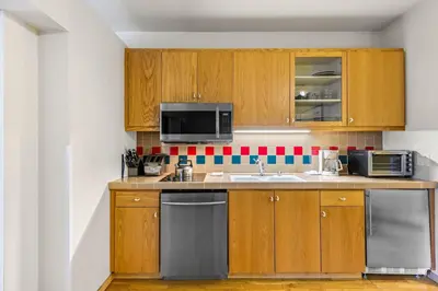 a kitchen with wooden cabinets and a sink and a microwave at Palisades Tahoe Lodge Rentals Studio #246 in Olympic Valley