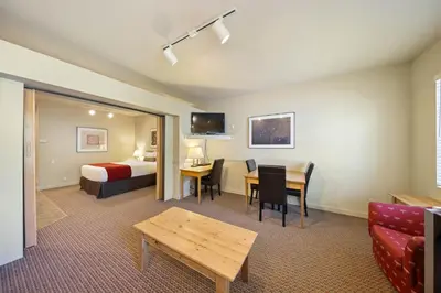 a hotel room with a bed and a desk and a table at Palisades Tahoe Lodge Rentals Studio #250 in Olympic Valley