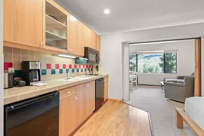 a kitchen with a sink and a couch in a room at Palisades Tahoe Lodge Rentals Studio #247 in Olympic Valley