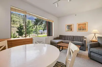a living room with a table and a couch at Palisades Tahoe Lodge Rentals Studio #247 in Olympic Valley