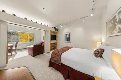 a bedroom with a large bed and a living room at Palisades Tahoe Lodge Rentals Studio #253 in Olympic Valley