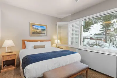 a bedroom with a bed and a large window at Palisades Tahoe Lodge Rentals Studio #255 in Olympic Valley