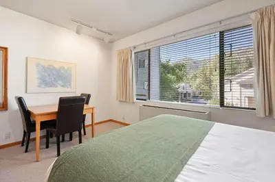 a bedroom with a bed and a desk and a window at Palisades Tahoe Lodge Rentals Studio #254 in Olympic Valley