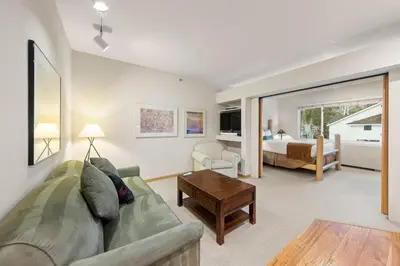 a living room with a couch and a bedroom at Palisades Tahoe Lodge Rentals Studio #256 in Olympic Valley