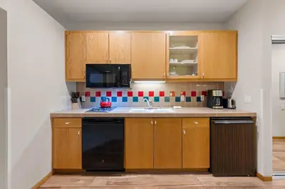 a kitchen with wooden cabinets and a black dishwasher at Palisades Tahoe Lodge Rentals Studio #256 in Olympic Valley