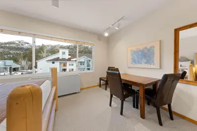a bedroom with a table and chairs and a bed at Palisades Tahoe Lodge Rentals Studio #256 in Olympic Valley