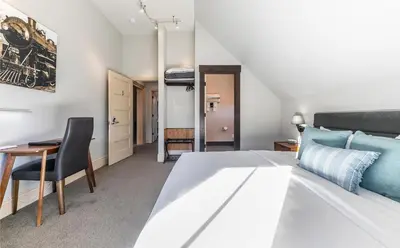 a bedroom with a bed and a table and a desk at Tahoe Star Hotel in Truckee
