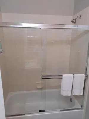 a shower with a glass door in a bathroom at Roseville Properties in Roseville