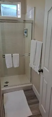 a bathroom with a shower with towels and a window at Roseville Properties in Roseville