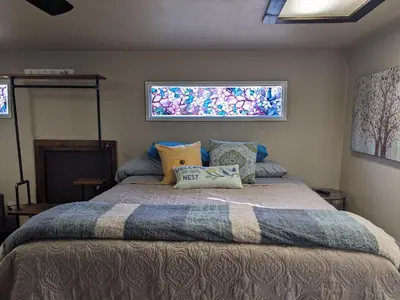 a bedroom with a large bed with two windows at Rustic Rooms Barn Loft (Upstairs Studio Apartment) Near Kings Canyon & Sequoia National Parks in Squaw Valley