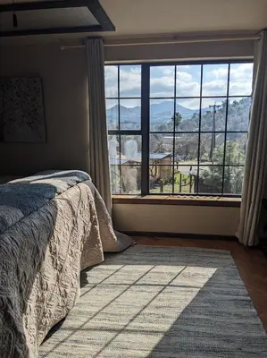 a bedroom with a bed and a large window at Rustic Rooms Barn Loft (Upstairs Studio Apartment) Near Kings Canyon & Sequoia National Parks in Squaw Valley