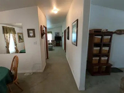 a hallway leading to a living room with a table and a shelf at Rr-kenton Hs in June Lake