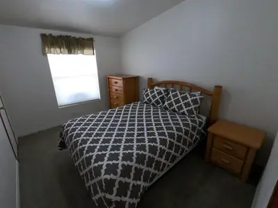 a bedroom with a bed with a black and white comforter and a window at Rr-kenton Hs in June Lake