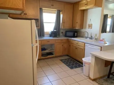 a kitchen with wooden cabinets and a white refrigerator at Rr-june Lake Lodge in June Lake