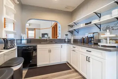 a large kitchen with white cabinets and a large mirror at Rustic 3-Bedroom, 1.5-Bath Oasis by Downtown in Reno