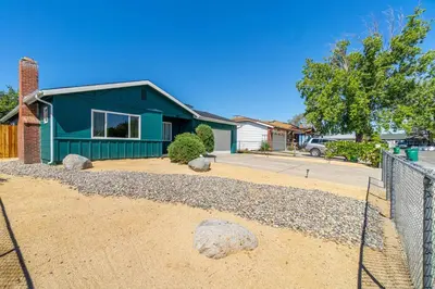 a blue house with a fence in front of it at Reno Serenade: 3-Bed Urban Sanctuary in Reno