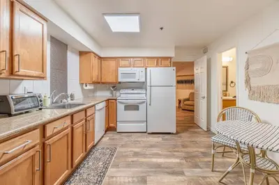 a kitchen with wooden cabinets and a white refrigerator at Stylish-Serene Midtown Getaway: Retreat for Two in Reno