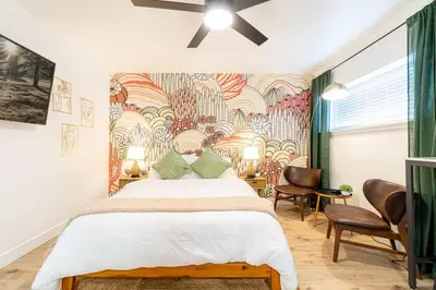 a bedroom with a large bed and a wall mural at Riverside Glam: Stylish Urban Escape in Reno