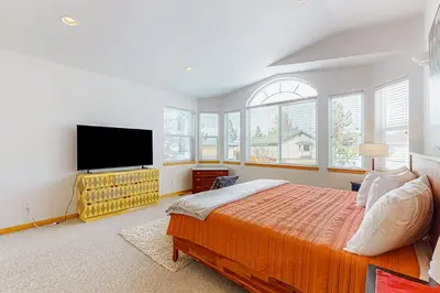 a bedroom with a large bed and a flat screen tv at Rooftop Retreat in South Lake Tahoe