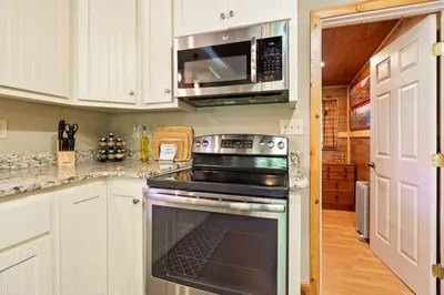 a kitchen with a stove and a microwave at Sugar Pine cabin in the woods King bed Fire pit in Oakhurst