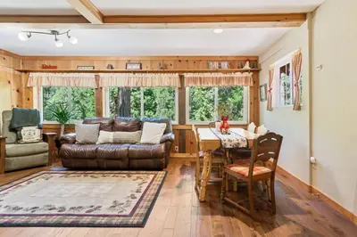 a living room with a leather couch and a table at Sugar Pine cabin in the woods King bed Fire pit in Oakhurst