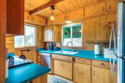 a kitchen with wooden cabinets and a blue counter top at Cozy Mi-Wuk Village Cabin 18 Mi to Dodge Ridge! in Mi-Wuk Village