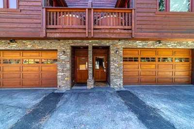 a house with two wooden garage doors on it at Luxury home close to Village; Garage & Jacuzzi in Mammoth Lakes