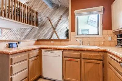 a kitchen with wooden cabinets and a white dishwasher at Snowcreek #309 2 Plus Loft, 2 Bathroom Condo Sleeps 8 People with Amazing Mountain Views in Mammoth Lakes