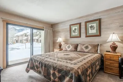 a bedroom with a bed and a large window at Snowcreek #309 2 Plus Loft, 2 Bathroom Condo Sleeps 8 People with Amazing Mountain Views in Mammoth Lakes