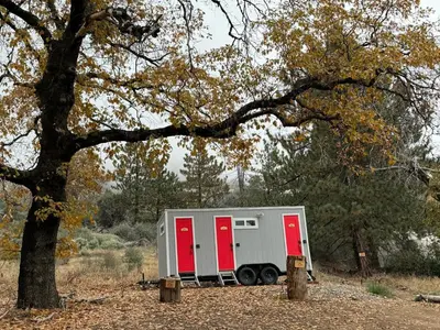 a white trailer with red doors parked under a tree at Mountain view Dome- 10 Minutes to National Park in Dunlap