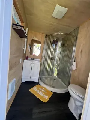 a bathroom with a shower and a toilet and a rug at Mountain view Dome- 10 Minutes to National Park in Dunlap