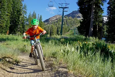 a young boy riding a bike down a trail at Lavishness at Elevation – Timber Ridge 3 Bedroom condo in Kirkwood