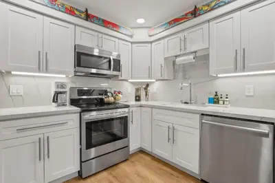 a white kitchen with stainless steel appliances and white cabinets at Luxury at Altitude – Base Camp 2 Bedroom condo in Kirkwood