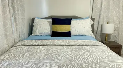 a bed with a blue and white comforter and pillows at Beautiful Spanish-Styled Home in Fresno