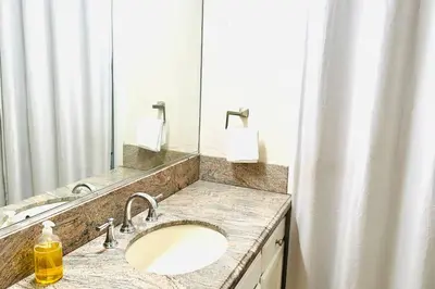 a bathroom with a sink and a large mirror at Beautiful Spanish-Styled Home in Fresno