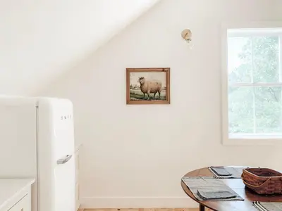 a kitchen with a table and a refrigerator at Homestead Barn Loft in Sonora