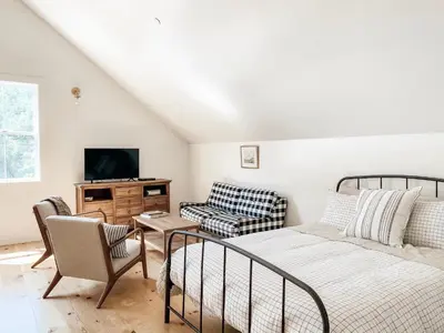 a living room with a bed and a tv at Homestead Barn Loft in Sonora