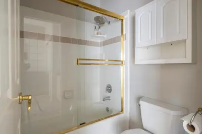 a bathroom with a shower and a white toilet at Balcony Suite Fraser Family Vineyard Stay in Amador in Plymouth