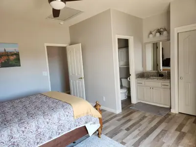 a bedroom with a bed and a bathroom at Balcony Suite Fraser Family Vineyard Stay in Amador in Plymouth