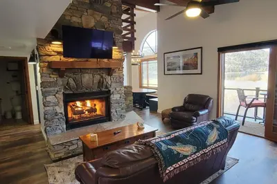 a living room with a couch and a fireplace at Lakefront Mountain Retreat in June Lake