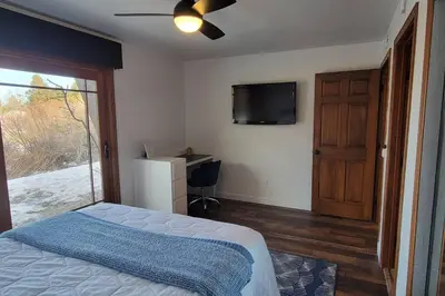 a bedroom with a bed and a flat screen tv at Lakefront Mountain Retreat in June Lake