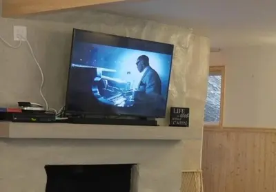 a flat screen tv sitting on top of a fireplace at Big Cabin on the Creek in Camp Connell